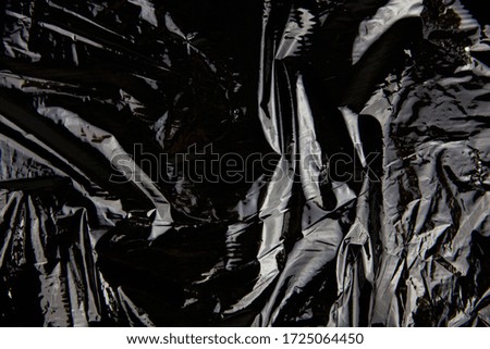 Black reusable plastic bag. Dark background for presentation of garbage recycling and nature conservation.