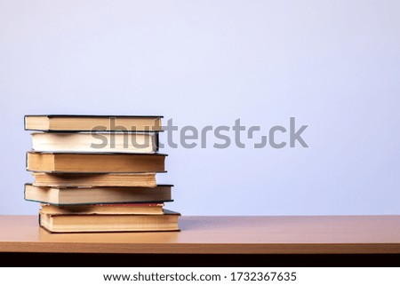 Stack of books on the table on a blue background. learning concept. literature.