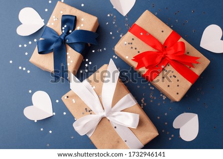 Red, blue and white gift boxes and white heart on classic blue background in the national colors of America, Russia, France or England, the concept of Independence Day, a national holiday