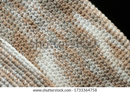 Fragment of crocheted canvas of melange yarn closeup. Abstract background