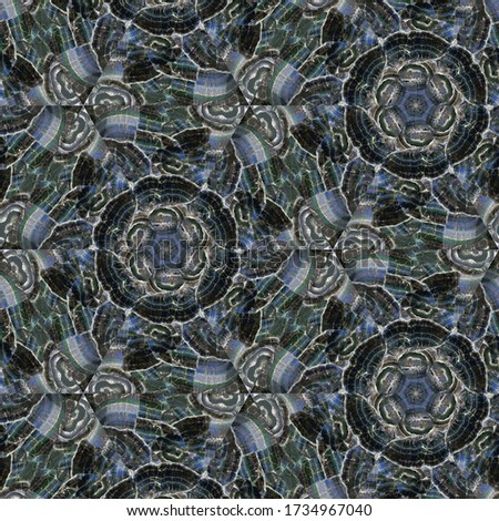 A symmetrical pattern formed by lines and spots of natural stone rhodonite texture. Amazing natural patterns and textures of slice of green,black and blue  minerals. The image with the mirror effect.