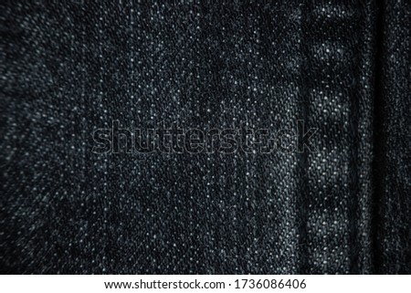 A seam on dark gray denim pants, close-up. Details textile, fabric, selective focus