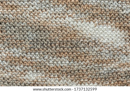 Fragment of crocheted canvas of melange yarn closeup. Abstract background