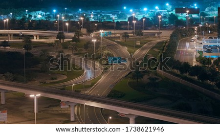 Aerial night view of empty highway and intersection in Dubai after epidemic lockdown. Cityscapes with disappearing traffic on streets. Roads and lanes crossroads without cars near JLT, Dubai, United