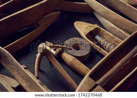 vintage wooden boat shuttles for hand weaving. The weft yarn is unwound from the tip of the pier when the shuttle is in motion and stops when the shuttle stops. spindle, manual spinning, 