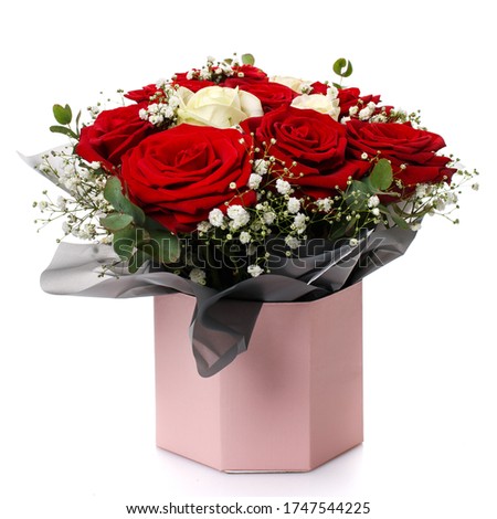 Red and white roses in a pink box on a white background. Celebrating a wedding, birthday or anniversary.