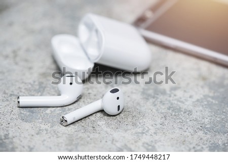 Pair of white wireless earbuds for smartphone. Relaxation concept.