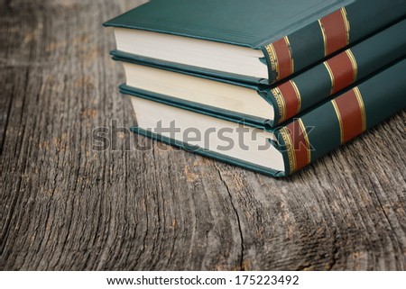 Green book on a textured wood background