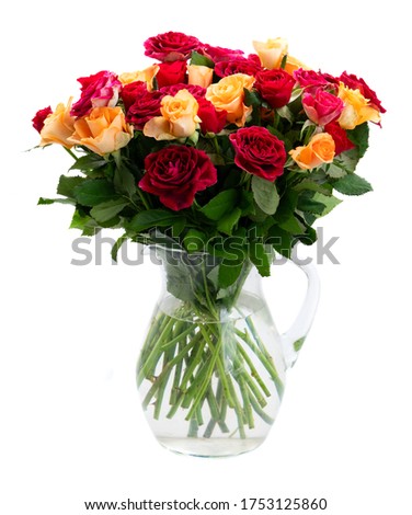 orange and red roses in glass vase