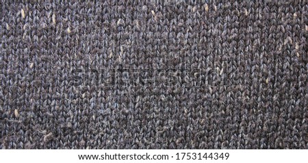 Gray woven knitted material texture design. Knit garment simple cloth pattern, thick wool fabric close up of grey color clothing. Knitted background surface for jacket or scarf warm apparel
