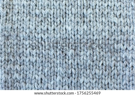 The texture of a knitted woolen fabric gray . Background