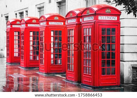 Traditional British red phone boxes in a row in Covent Garden, London. Colour removed from background to make the red stand out. 