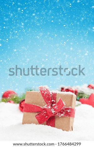 Christmas greeting card with decor and gift box in snow over blurred bokeh background and copy space for your xmas greetings