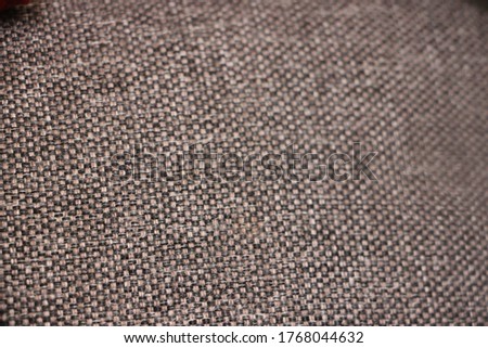 Background of beige brown and black threads textile texture closeup.