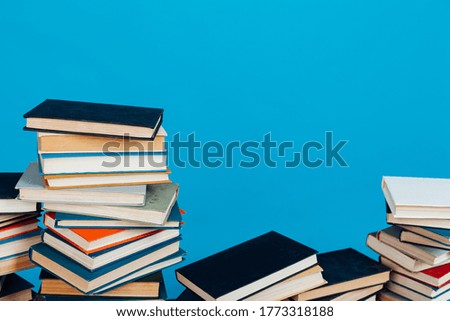 many stacks of educational books for exams in the library on a blue background