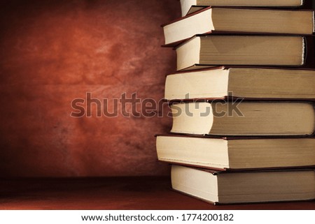 A pile of old on a wooden table. reading habit concept. A stack of old books on a wooden background.