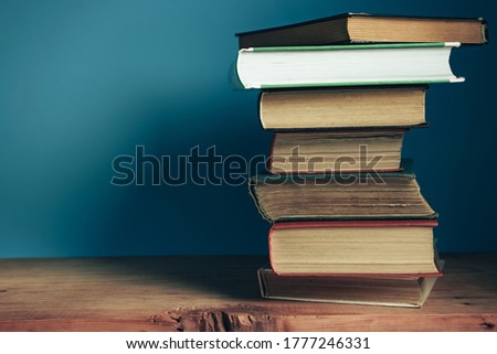 Beautiful open books on a old red wooden table and blue wall background.