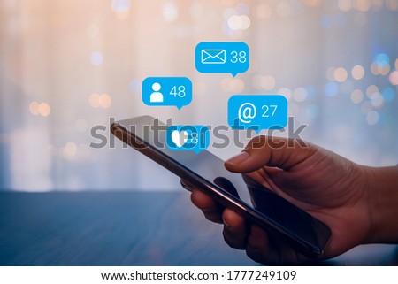 Person hand using a mobile phone with social media marketing concept.