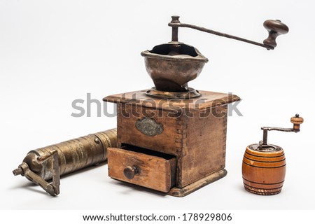 Three vintage hand grinders on a white background