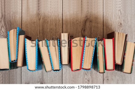 Books textbook in colorful covers on a wooden background. Back to school distance home education.Quarantine concept of stay home