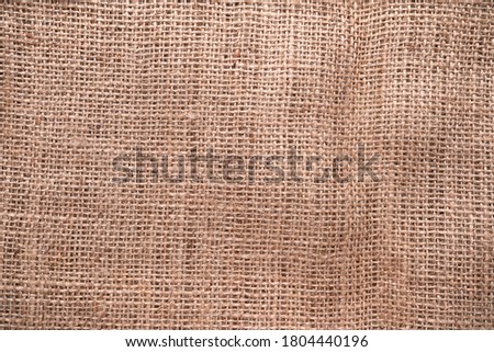 A closeup top view of natural hessian material texture background fabric.