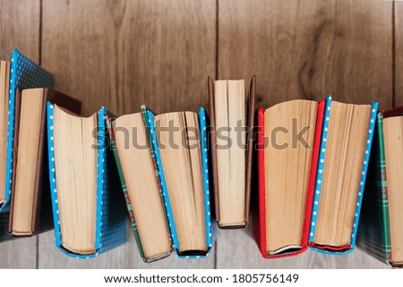 Books textbook in colorful covers on a wooden background. Back to school distance home education.Quarantine concept of stay home