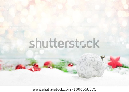 Christmas greeting card with decor in snow over blurred bokeh background and copy space for your xmas greetings