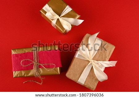 Different christmas gift boxes on red background, top view.