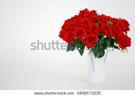 Red rose in white vase on white background