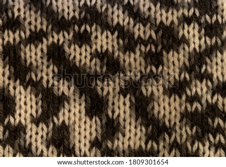 Knitted fabric made of melange wool yarn.