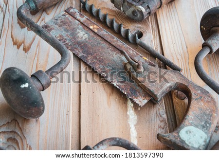 ,vintage  hand tools. on wooden table ,saw and hand drill  & bit labour day.