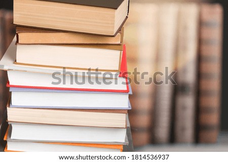 Stack of colored study books on library background