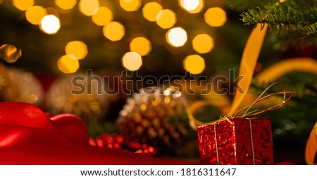 Xmas banner with christmas decorations: cone, balls, tape, beads, gift box and Christmas tree on garland bokeh background. Copyspace. New year congratulations card