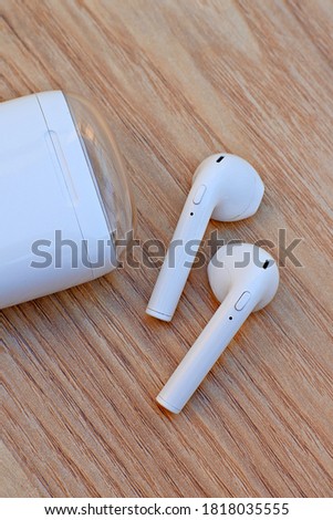 White true wireless stereo earphones with power bank case on the wooden background