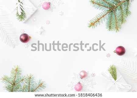 Flat lay frame with fir branches, christmas baubles decoration and gift box on a white background