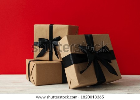Gift boxes on wooden table against red background