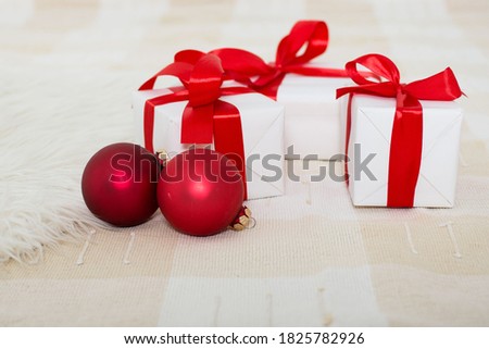 White Christmas gift boxes with red ribbon and Christmas balls. Christmas congratulations concept.