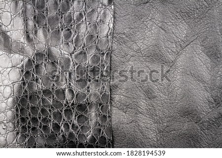 Black leather and fake artificial alligator skin textures background.