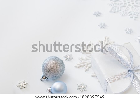 Frame with christmas baubles decoration and gift box on a white background