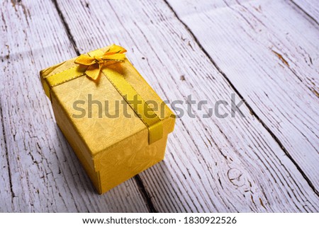 Yellow gift box with bow ribbon on the white wooden background, birthday, Christmas, Valentine day concept. accept gifts concept