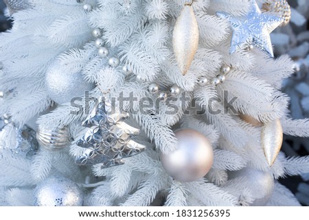 Christmas decoration, festive background with a white Christmas tree, garland and toys. Christmas tree, ball and icicle