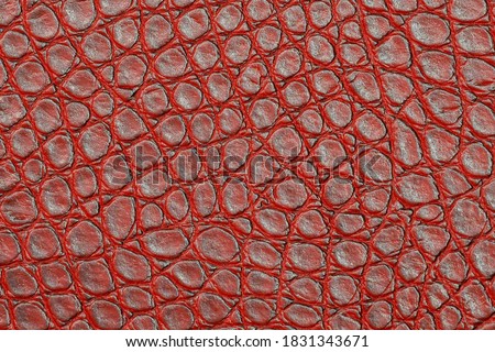 Artificial leather texture with abstract red pattern. Animal crocodile skin imitation background