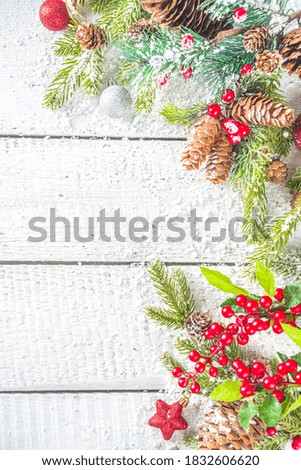 Christmas and New Year greeting card background. Xmas backdrop with fir tree branches, decoration and snowfall on wooden white board 