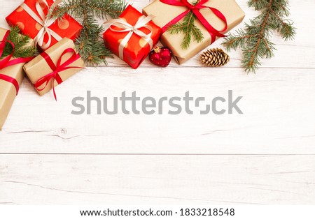 Merry Christmas frame and wallpaper. Happy New Year composition. Christmas gift, red berries, heart shape ball, pine cones, fir branches on wooden white background. Top view and copy space