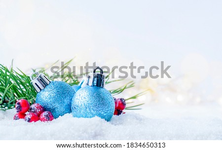christmas ornament, berries and fir branches in the snow