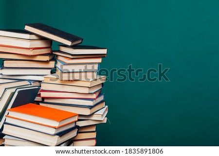 stacks of books for education in the university library on the green background of the place for the inscription