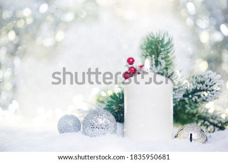 Christmas decoration with candles, fir branch and balls on snow