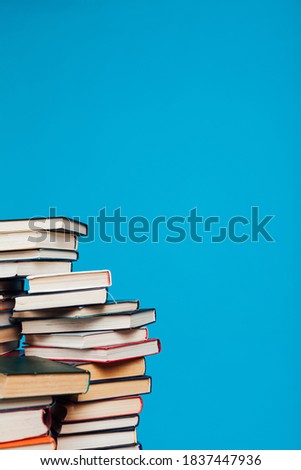 stacks of books for education in the college library on a blue background place for inscription