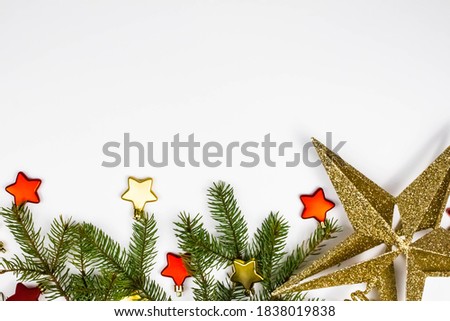 Beautiful holidays background of green spruce branches on white decorated with Christmas accessories. Top view, space for text. Happy new year