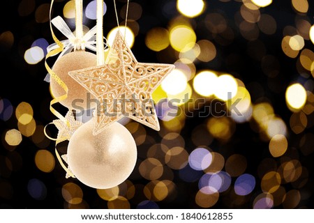 Hanging golden christmas balls decorations on black festive background with copy space